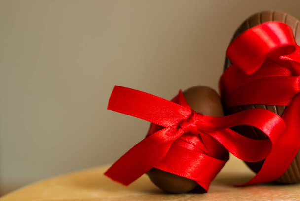 Huevos de Pascua grandes y pequeños de chocolate con cinta roja
 - Foto, Imagen