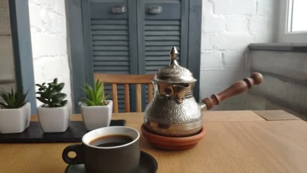 Primer plano de una cafetera con café natural, una taza de café en la mesa, café para el desayuno, buenos días
. - Metraje, vídeo