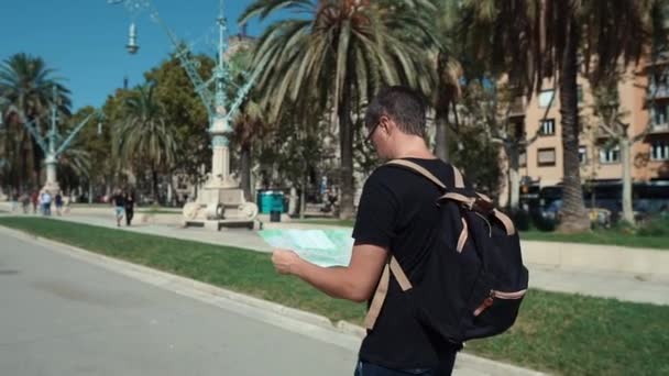 Male reiziger is een wandeling alleen op City Street, het bekijken van Paper map - Video