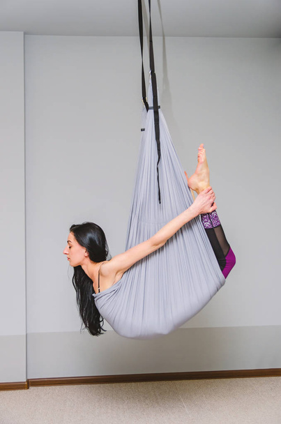 стройный тренер по йоге летает на йоге в гамаке в студии
. - Фото, изображение