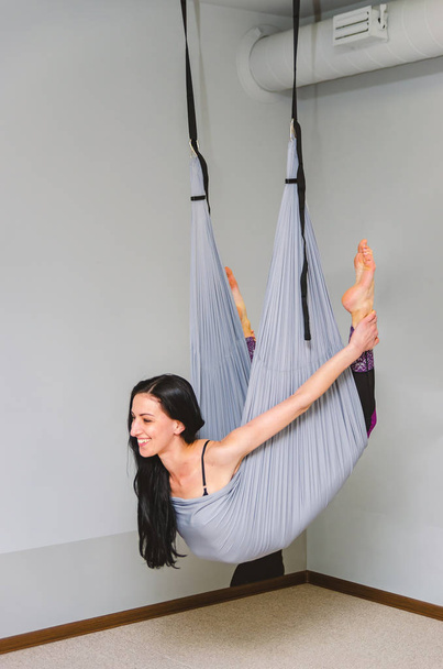 slim, fit yoga trainer hace volar yoga en una hamaca en el estudio
. - Foto, Imagen