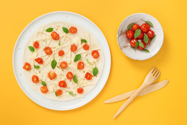 Vegetarian tortilla and tomatoes on yellow background - Foto, Bild