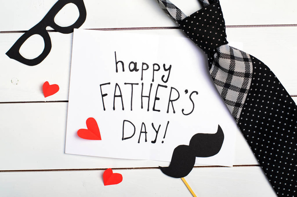 Concepto del día del padre, corbata, bigote, gafas y tarjeta de felicitación
 - Foto, imagen