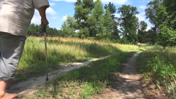 Sobreponderado hombre mayor que se aleja en un camino de tierra de verano descalzo
 - Metraje, vídeo