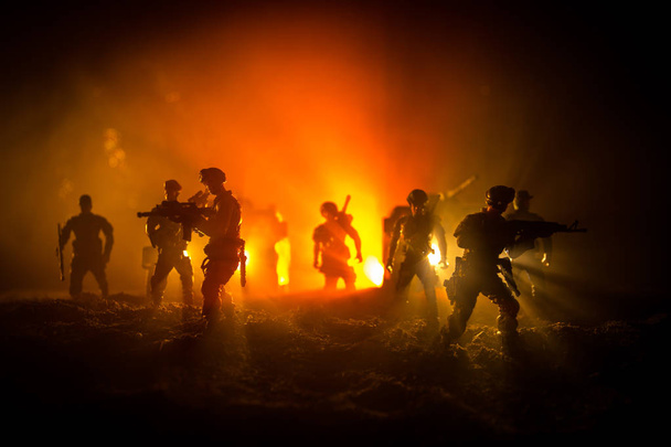 Концепция войны. Сцена сражения на фоне тумана войны, боевые силуэты под облачным горизонтом ночью. Армейский автомобиль с украшениями для солдат
 - Фото, изображение