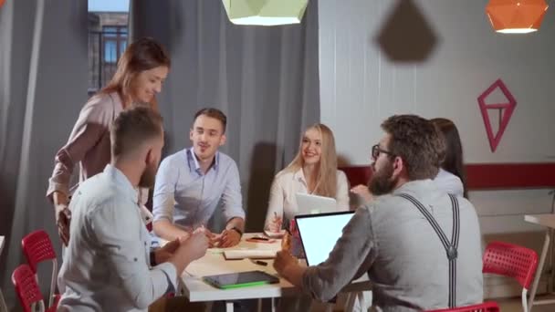 De jonge creatieve mensen bespreken in bureauruimte, het glimlachen en het lachen - Video