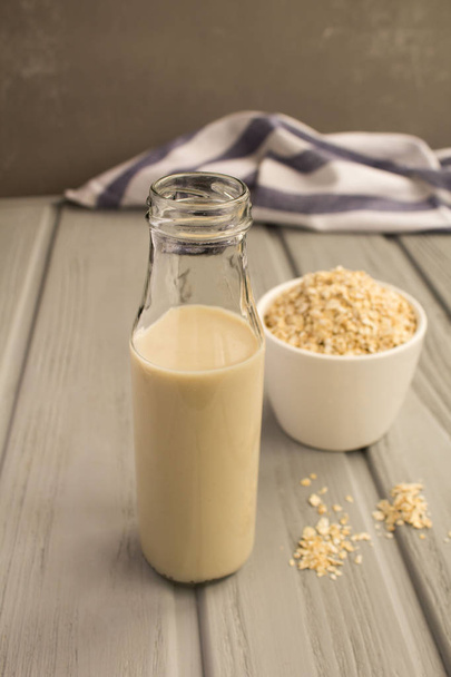 Oat milk in the glass bottle on the grey background.Healthy drink. - Foto, immagini