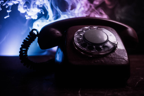stary telefon czarny na stare deski z ciemne tło z mgły i stonowanych światła. puste miejsce. Selektywny fokus - Zdjęcie, obraz