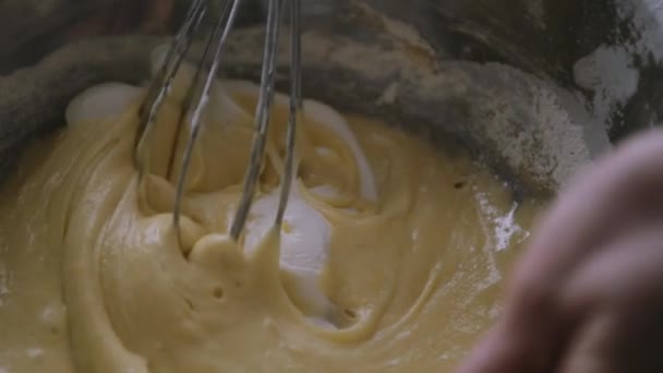 Henkilö valmistelee kotitekoista munakasta sekoittamalla munia käsin Corolla
. - Materiaali, video