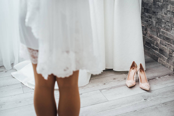 Cropped view of legs of bride in white wedding dress - Photo, image