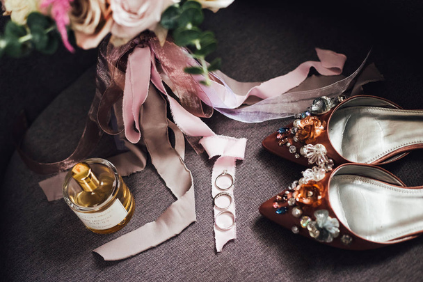 Bridal shoes and ribbons with wedding rings, still life - 写真・画像