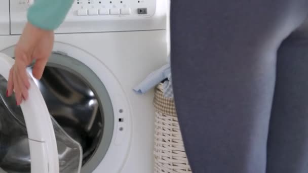 Woman loads the laundry in the washing machine - Footage, Video