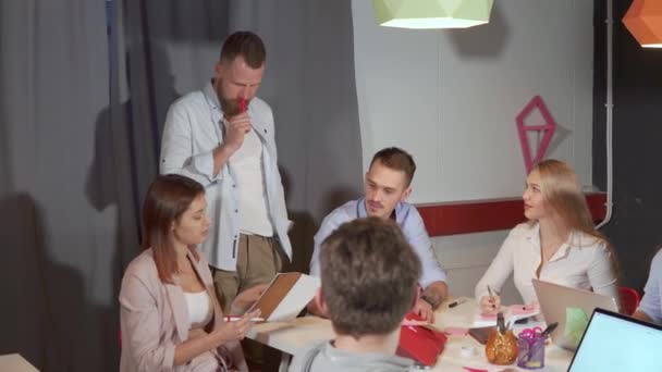 Zakelijke sessie in kantoorruimte, jongeren zitten aan tafel - Video