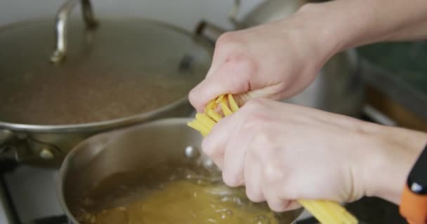 Tészta spagetti helyezi egy fazék forró víz - Felvétel, videó