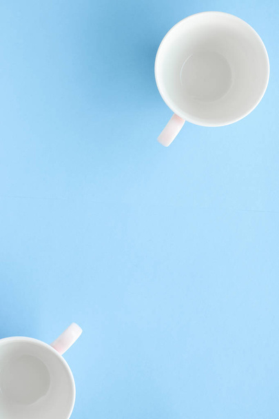 Empty cup and saucer on blue background, flatlay - Foto, imagen
