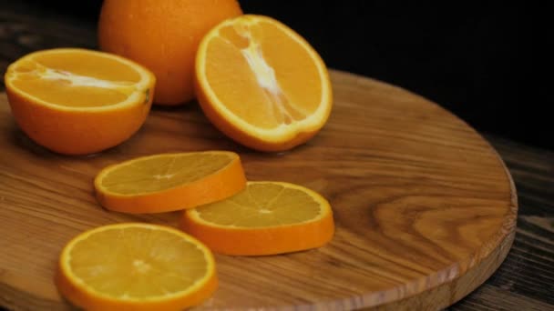 Close up of fresh colorful oranges on black wooden table - Felvétel, videó