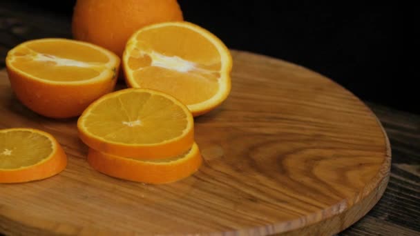 Close up of fresh colorful oranges on black wooden table - Felvétel, videó