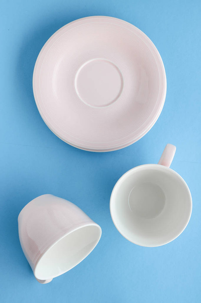 Boş Kupası ve fincan tabağı üzerinde mavi arka plan, flatlay - Fotoğraf, Görsel
