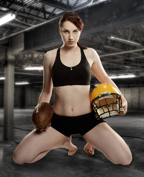 Young woman with helmet and football against a grungy background - Fotografie, Obrázek