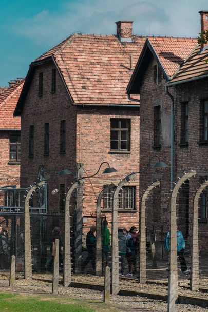 Освенцим, Польша - 21 сентября 2019 года: Туристы прошли через ворота нацистского концентрационного лагеря Освенцим
  - Фото, изображение