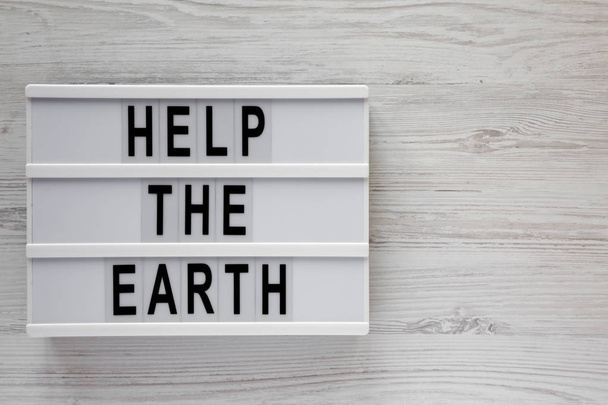 'Help the Earth' words on modern board over white wooden backgro - Photo, Image