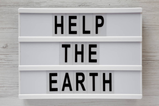 'Help the Earth' words on lightbox over white wooden background, - Photo, Image