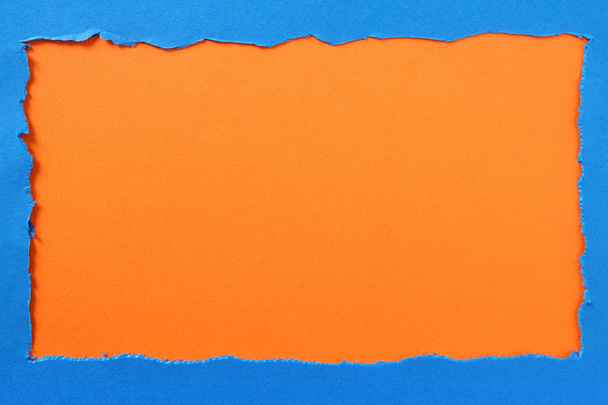 Torn blue paper orange background border frame - Foto, Bild