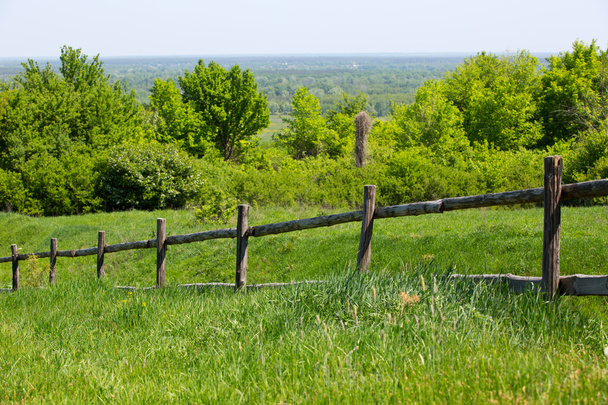 Забор на зеленом лугу
 - Фото, изображение