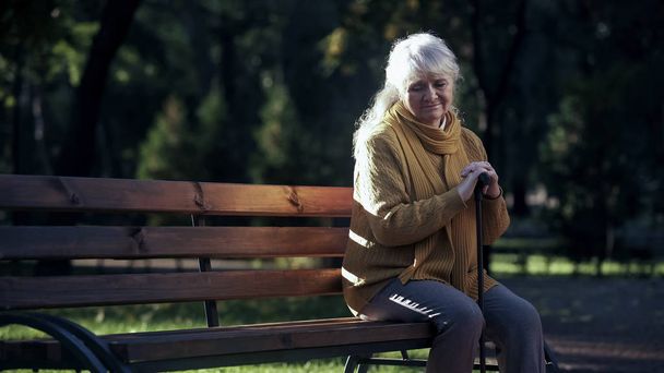 Sad lonely old woman sitting on bench in park, abandoned elderly people alone - Zdjęcie, obraz