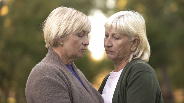 Two sad women with sorrowful eyes supporting each other, family loss, life - Foto, Imagem