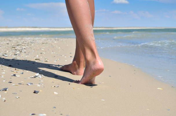 Girl walking barefoot on the sand of the sea beach - Photo, Image