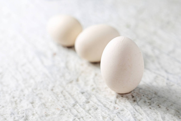 White chicken eggs on a stone table. - Φωτογραφία, εικόνα