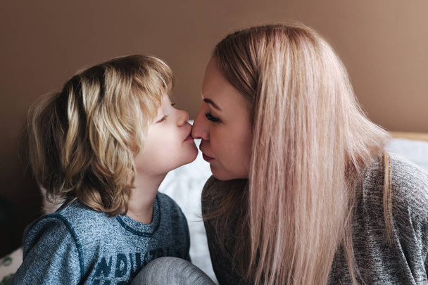 Sohn küsst seine Mutter. Mutter und Sohn. glücklicher Muttertag. Mutter umarmt ihr Kind zu Hause - Foto, Bild