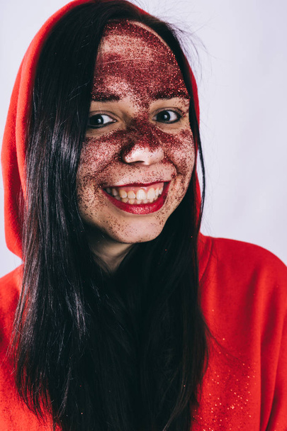 young woman with red glitter on her face posing  - Valokuva, kuva