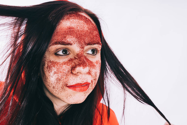 young woman with red glitter on her face posing  - Fotó, kép