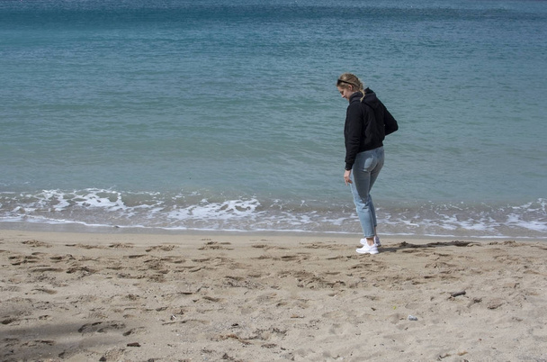 Молода мила жінка гуляє на піщаному пляжі навесні
 - Фото, зображення