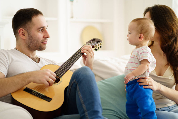 father playing guitar for mother and son. leisure - Φωτογραφία, εικόνα