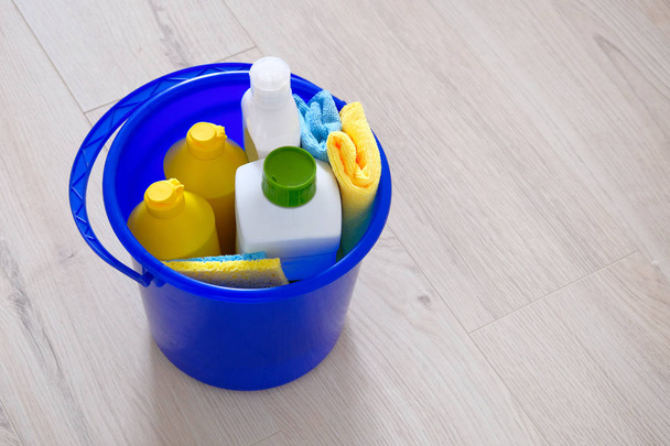 Detergentes en botellas de plástico, esponjas, cepillo en cubo de uso doméstico azul. Guante de goma amarillo. Concepto de servicio. Copiar espacio
. - Foto, imagen