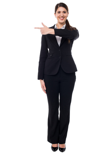 Attractive corporate woman pointing away - Foto, afbeelding