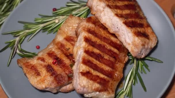 Καυτό κρέας. Κομμάτια από ψητό χοιρινό περιστρέφονται σε ένα πιάτο - Πλάνα, βίντεο