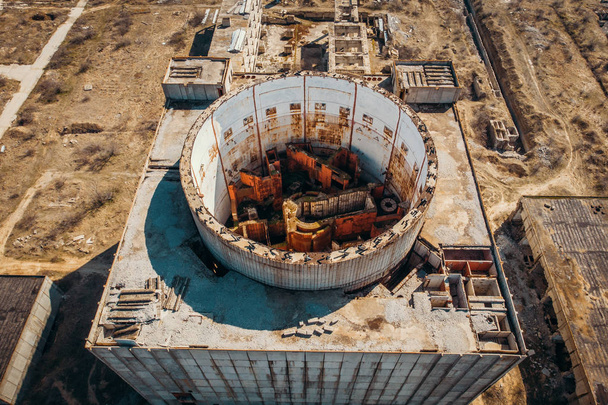 Vue aérienne du sommet de la centrale nucléaire abandonnée et en ruine à Shelkino, en Crimée. Grande construction industrielle de l'URSS avec tour ronde de réacteur atomique
 - Photo, image