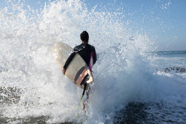 サーフィンに行くサーフボードを持つ女性サーファー - 写真・画像