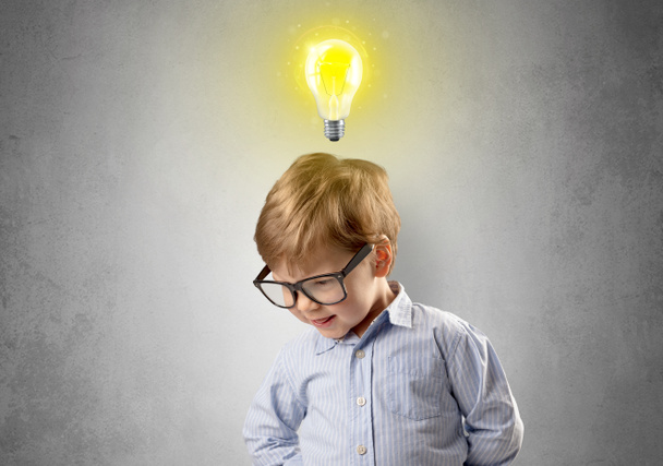 Little boy mull over with bulb above his head - Foto, imagen