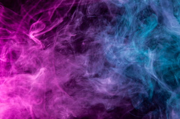 Fumo denso multicolore di colori blu e rosa su uno sfondo nero isolato. Sfondo di fumo vap
 - Foto, immagini