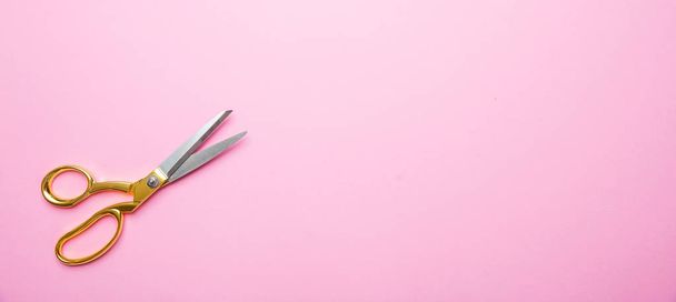 Ножиці з золотою ручкою на рожевому фоні, банне, простір для копіювання, вид зверху
 - Фото, зображення