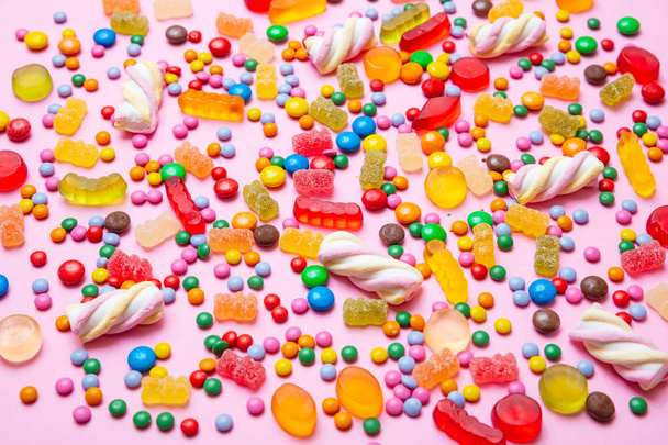 Η ιδέα των γενεθλίων. Πολύχρωμα γλυκά ζαχαρωτά σε ροζ φόντο - Φωτογραφία, εικόνα