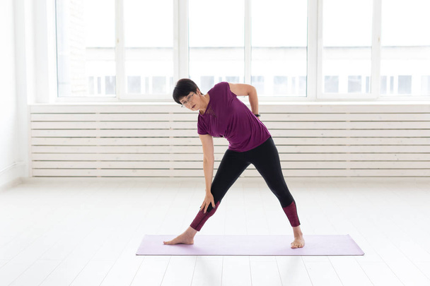 Yoga, concept de personnes une femme d'âge moyen faisant un yoga et essayer de faire un asana
 - Photo, image