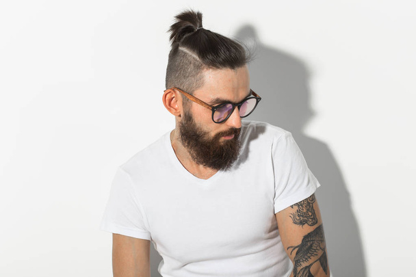 Schönheits-, Mode- und People-Konzept - Porträt eines Hipster-Mannes mit Bart vor weißem Hintergrund - Foto, Bild
