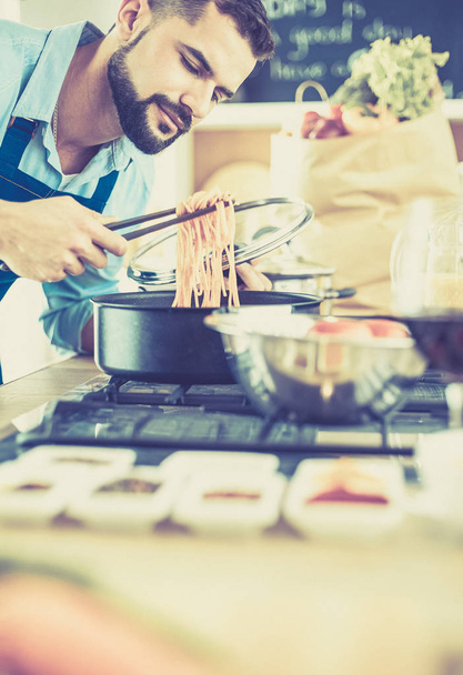 Homem preparando comida deliciosa e saudável na cozinha da casa - Foto, Imagem