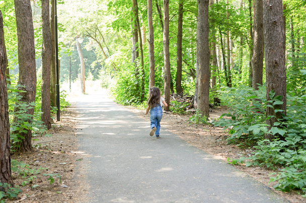 Kinder, Kindheit und Naturkonzept - Rückansicht des schönen kleinen Mädchens, das im Park läuft - Foto, Bild